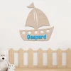 Décoration murale en bois représentant un bateau à personnaliser au prénom de l'enfant, destinée pour une chambre de bébé